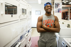 Student smiles while doing laundry