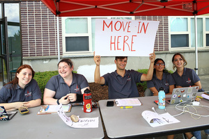 student holding move in sign